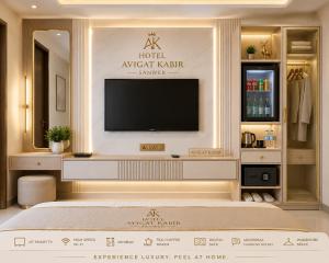 a bedroom with a tv on a wall at Avigat Kabir hotel sanwer in Sānwer