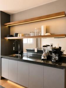 a kitchen with white cabinets and a black counter top at Modernos departamentos tipo LOFT a dos calles del estadio in Boca del Río