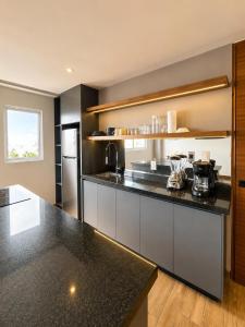 a kitchen with a black counter top and a refrigerator at Modernos departamentos tipo LOFT a dos calles del estadio in Boca del Río