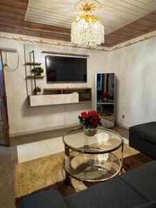 a living room with a glass table and a television at AFRAAH GUEST House 2 in Yaoundé