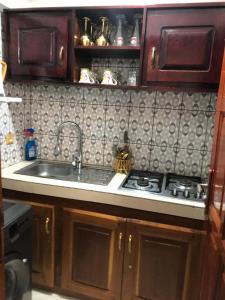 a kitchen with a sink and a stove at AFRAAH GUEST House 2 in Yaoundé