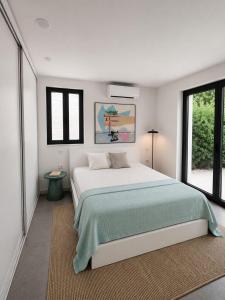 a white bedroom with a large bed and windows at Casa Bol Old Town in Bol