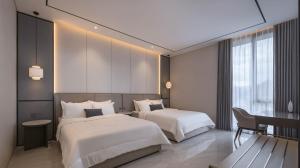 a hotel room with two beds and a desk at Alcola Boutique Villa - Caspia Unit in Tlekung
