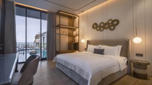 a bedroom with a large bed and a balcony at Alcola Boutique Villa - Caspia Unit in Tlekung
