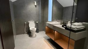 a bathroom with a toilet and a sink and a mirror at Alcola Boutique Villa - Caspia Unit in Tlekung