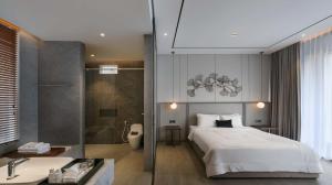 a bedroom with a bed and a bathroom with a shower at Alcola Boutique Villa - Dania Unit in Tlekung