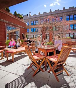 Eine Gruppe Mädchen, die an einem Tisch auf einer Terrasse sitzen in der Unterkunft Hotel Giraffe by Library Hotel Collection in New York