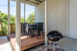 a deck with a table and chairs on it at 波の音テラス富津ー海眺望グッドデザイン受賞別荘を最大7名1棟貸切 in Futtsu