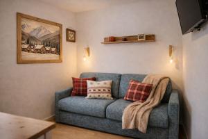 a living room with a blue couch with red pillows at Suite Bormio - with WIFI & Netflix in Piatta