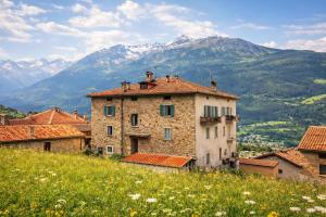 an old building on a hill with mountains in the background at Suite Bormio - with WIFI & Netflix in Piatta