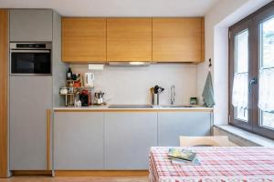 a kitchen with white cabinets and a counter top at Suite Bormio - with WIFI & Netflix in Piatta