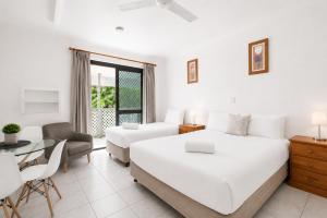 a white bedroom with a bed and a dining room at Motel Ingham in Ingham