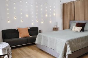 a bedroom with a bed and a couch at The Cozy Beach Studio in San Juan