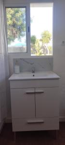 a bathroom with a white sink and a window at L'évidence in Alcantarilha +2 photos
