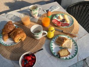 a table with plates of food and cups of coffee at A Villa Rosa in Santa-Maria-di-Lota