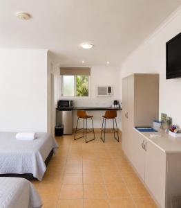 a bedroom with a bed and a kitchen with a table at Motel Ingham in Ingham