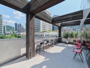 a rooftop patio with tables and chairs on a building at 수수하우스 서울 in Seoul
