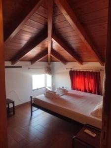 a bedroom with a large bed with a red curtain at Kratounis Apartment 1 in Oikonomiánika