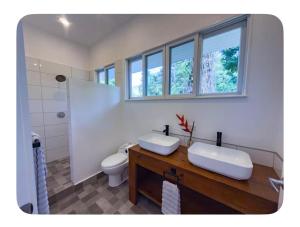 a bathroom with two sinks and a toilet at Spot on Drago in Bocas Town +18 photos