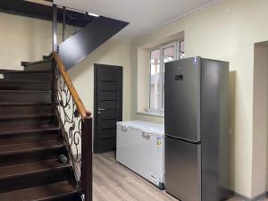 a kitchen with a refrigerator next to a staircase at Moto Guest House in Kochkorka