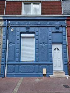 a blue building with two windows and a door at Naëlle in Calais
