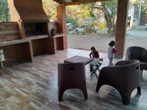 two children sitting at a table in a patio with chairs at Graciela in Villa Las Rosas
