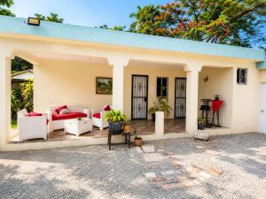 a home with a patio with white furniture at Bon Appetit Hotel & Restaurant Barahona in Santa Cruz de Barahona +2 photos