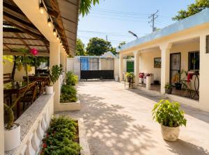 a courtyard of a house with plants and a patio at Bon Appetit Hotel & Restaurant Barahona in Santa Cruz de Barahona