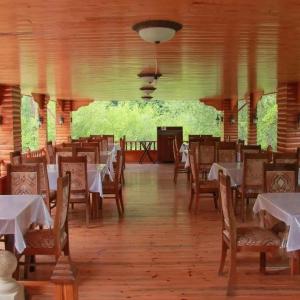 a dining room with white tables and chairs at Narınqala Hotel in Sheki