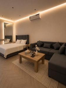 a living room with a bed and a couch at Luxury Smart Entry Studio in Buraydah