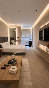 a large bedroom with a large bed and a table at Luxury Smart Entry Studio in Buraydah