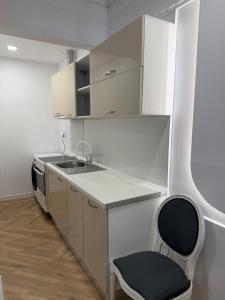 a kitchen with a black chair and a sink at Tempo apartments in Pazardzhik +15 photos