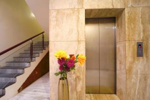 a vase of flowers in front of a elevator at YAFA Palace in Rāmanāthapuram +11 photos