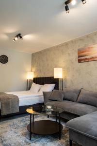 a living room with a bed and a couch at Apartament Targowa 9A41 in Uniejow