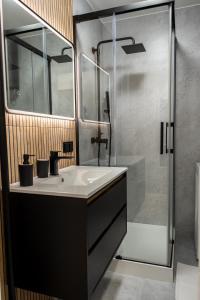 a bathroom with a sink and a shower at Apartament Targowa 9A41 in Uniejow +7 photos