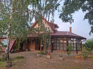 a house with a tree in front of it at Casa cu şemineu in Păuşa