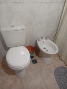 a bathroom with a white toilet and a sink at Casa Amarilla in Luján