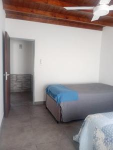 a bedroom with a bed and a ceiling fan at Casa Amarilla in Luján