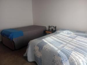 two beds in a small room with a bedskirts at Casa Amarilla in Luján