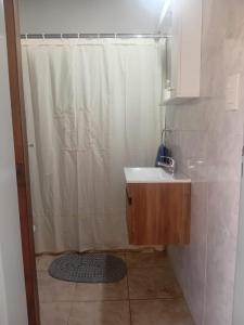 a bathroom with a shower curtain and a sink at Casa Amarilla in Luján