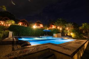 a swimming pool in front of a house at night at Druwa Bali in Uluwatu +15 photos