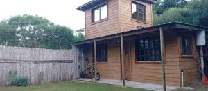 a wooden house with a bicycle parked in front of it at Casa en Marindia Sur in Salinas