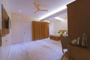 a living room with a bed and a ceiling fan at YAFA Palace in Rāmanāthapuram