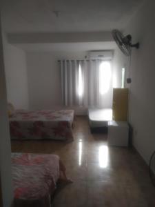 ein Hotelzimmer mit zwei Betten und einem Fenster in der Unterkunft Ebora Afro economy in Ilhéus + 7 Fotos