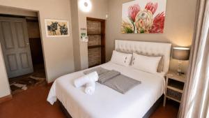a bedroom with a large white bed with towels on it at Singwe Private Safari Lodge Kruger in Marloth Park