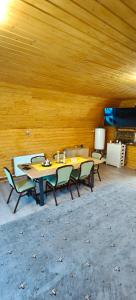 a group of tables and chairs in a room with wooden walls at Cabana A frame Nămăiești in Nămăeşti