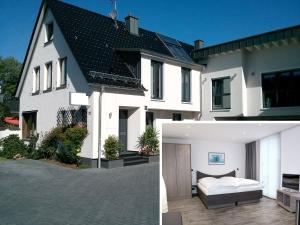 a white house with a bed in a courtyard at Apartments Peters in Burscheid
