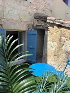 a building with a blue door and a plant at Escale Tropicale in Lectoure +2 photos