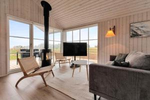 a living room with a couch and a fireplace at 16666-Farevejle-Karuphoj-4-E in Fårevejle