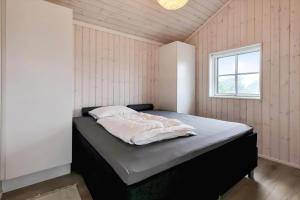 a bedroom with a bed in a room with a window at 16666-Farevejle-Karuphoj-4-E in Fårevejle